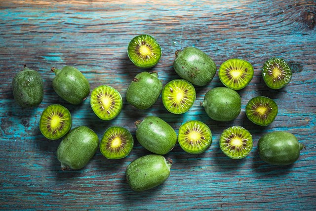 Kiwifruits on colored table, decorative photo,